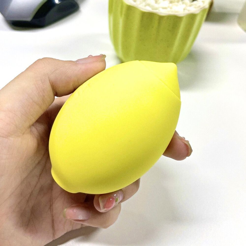 Vibromasseur citron jaune tenu dans une main, forme ergonomique.
